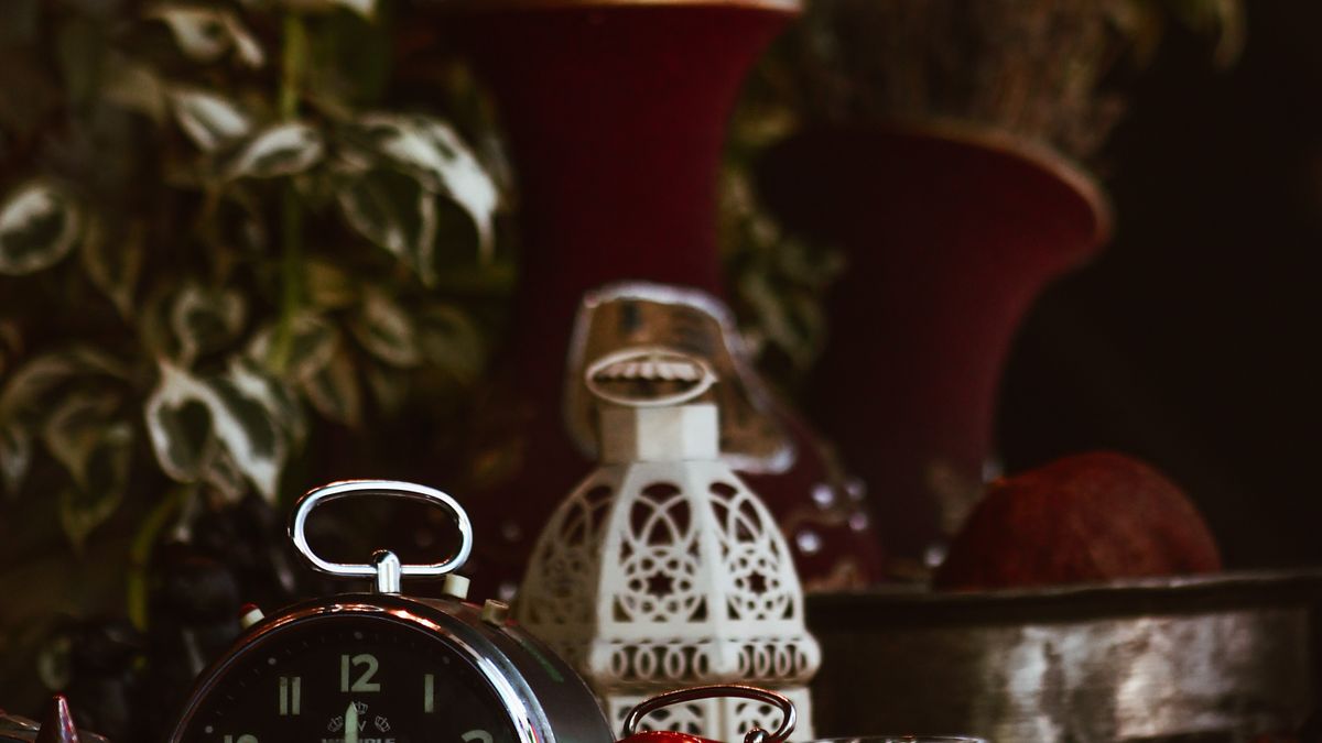 Jam dinding dan cangkir kopi di meja kerja yang tenang